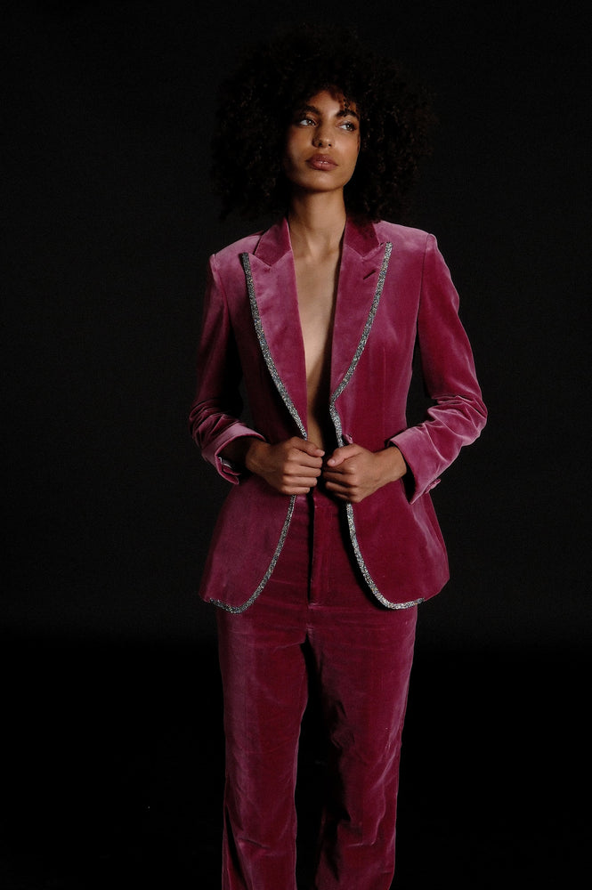 
                  
                    Woman wearing custom tailored suit in hot pink velvet with piping 
                  
                