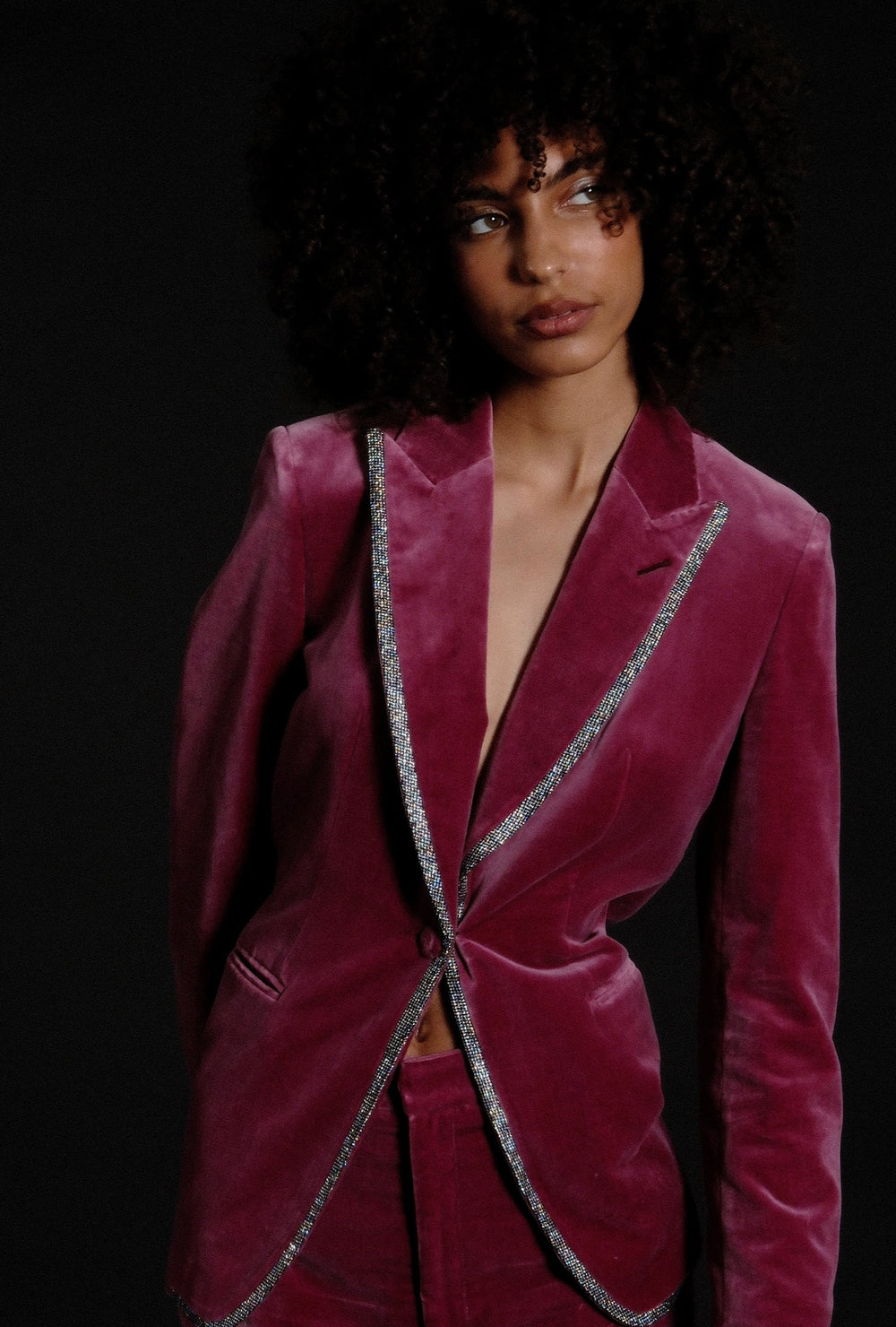 Woman wearing custom tailored suit in hot pink velvet with piping 